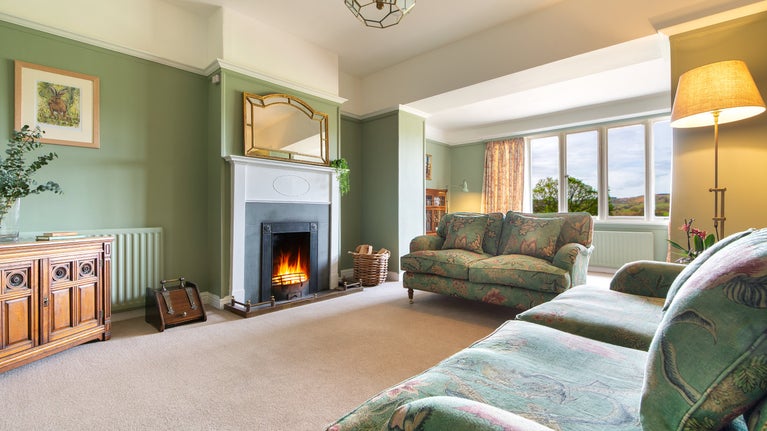 The sitting room with open fire at Cragside Park Cottage, Northumberland